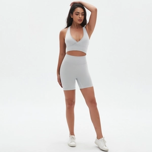 Dettaglio del set yoga grigio chiaro senza cuciture con reggiseno incrociato e pantaloncini