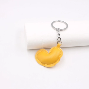 Detail of yellow heart-shaped PU leather keychain with sturdy metal ring and chain