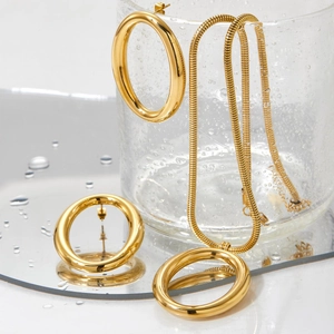 Gold hollow oval jewelry set with thick snake chain and stud earrings on mirror base