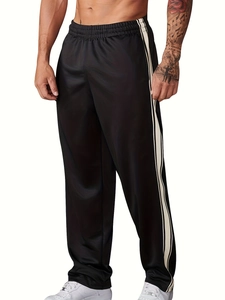 Close-up of black joggers with white side stripes and elastic waistband for men