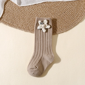 Detail of baby knee-high knit sock in khaki with floral fabric and pearl accents