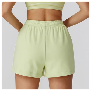 Dettaglio dei pantaloncini sportivi verde chiaro con elastico in vita e strisce bianche