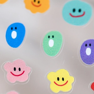 Colorful emoji nail art stickers with smiles and expressions on transparent backing