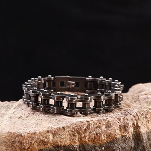 Macro shot of punk style bicycle chain bracelet in antique silver on rock background