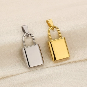Polished gold and silver padlock pendants on beige silk fabric for DIY jewelry making