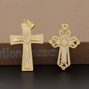 Macro shot of two 18k gold plated hollow cross pendants with sparkling zircon stones