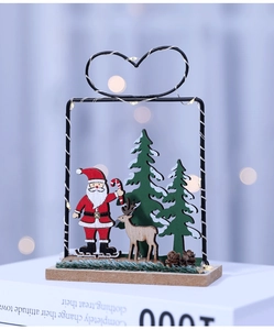 Close-up of wooden Santa ornament with LED wire heart frame and natural pine cones