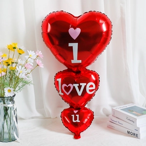 Detail view of red heart foil balloons with I Love U print and floral background