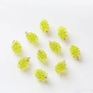 Detailed view of ten light green resin grape pendants with gold loops for DIY jewelry