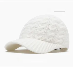 Macro detail of off-white knitted baseball cap showing chunky cable knit and ribbed texture