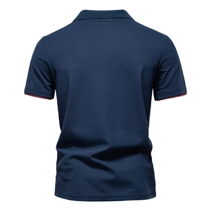 Detail of navy blue polo shirt with textured pique fabric and red contrast sleeve trim