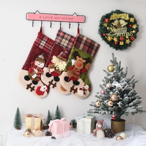 Three-piece Christmas stocking set with Santa, Snowman, and Reindeer in home setting