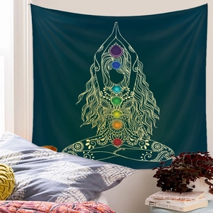 Detail of meditation tapestry with golden yoga silhouette and seven chakra symbols on green