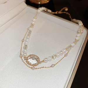 Detailed macro view of a vintage double-layer pearl necklace with a faceted gem pendant