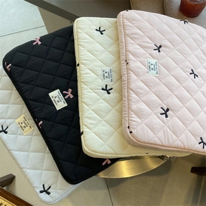 Quilted laptop sleeve with cute bow embroidery and soft lining, perfect for daily use.