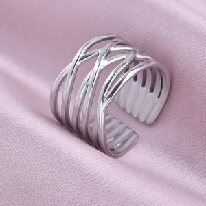 Macro shot of silver multi-layer woven adjustable ring on elegant pink silk fabric