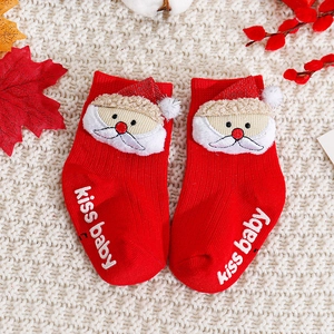 Close-up of red Christmas baby socks with 3D Santa and non-slip kiss baby soles