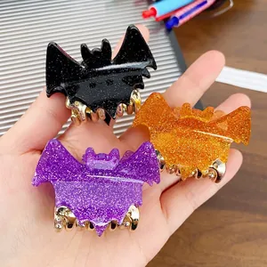 Three-piece Halloween bat hair clips in glittery black, purple, and orange acrylic