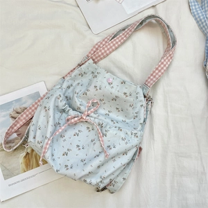 Floral canvas shoulder bag detail featuring pink plaid bow and snap button closure