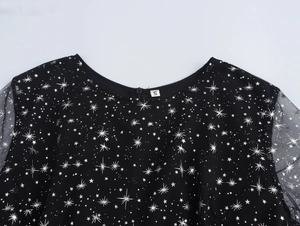 Dettaglio vestito in mesh nero con stelle argento e scollo rotondo con etichetta taglia S
