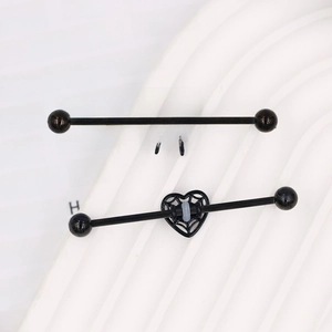 Macro detail of black industrial barbell earrings featuring spider and heart web designs