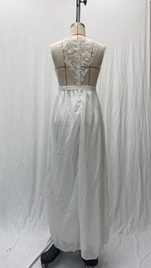 Detail of white lace bodice with elegant floral patterns and a V-shaped open back