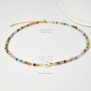 Detailed macro view of colorful faceted crystal beads and oval freshwater pearl on necklace