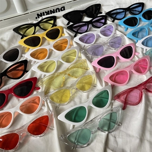 Flat lay of cat-eye sunglasses in various jelly colors on white draped fabric background