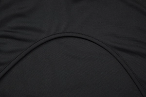 Détail de robe en tricot noir montrant les coutures incurvées et la texture du tissu de qualité