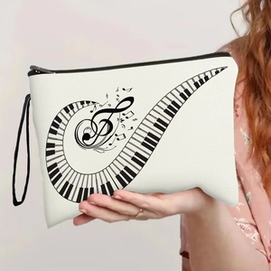 White canvas pouch with piano keys and notes print, held by a model on grey background