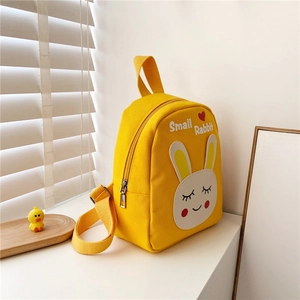 Close-up of cute cartoon rabbit embroidery on a bright yellow canvas toddler backpack