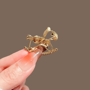 Elegant gold rocking horse brooch with white cubic zirconia accents for women