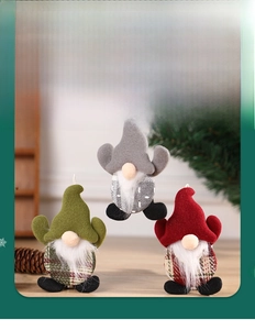 Close-up of three plush Christmas gnomes with hanging strings for festive decor
