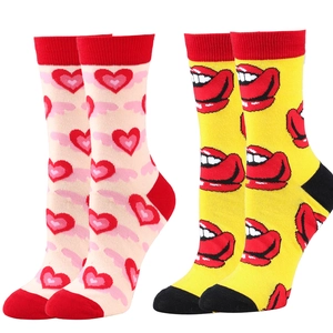 Detail of cotton crew socks featuring pink heart and yellow lip patterns with red heels