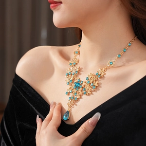 Detail of vintage gold necklace featuring blue floral zirconia and waterdrop pendant