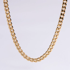 Macro view of polished golden cuban chain necklace with classic curb links and metallic luster