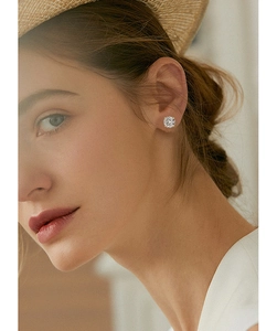 Close-up of classic four-prong moissanite stud earring worn on model's ear
