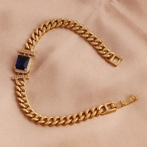 Detail of a gold-plated bracelet with blue square zircon and clear pavé on champagne silk