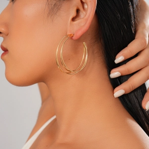 Close-up of elegant gold multi-layer geometric C-shaped hoop earrings on female model