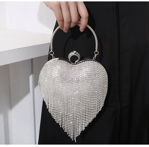 Detail of silver heart evening bag with sparkling rhinestones and flowing tassel fringes