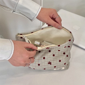 Dettaglio della grande borsa per cosmetici a quadri con pois rossi e fodera interna morbida