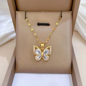 Macro view of gold butterfly pendant featuring drop-shaped zircons on a velvet jewelry box