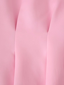 Vue macro du tissu rose montrant les détails de texture avec plis et coutures fines