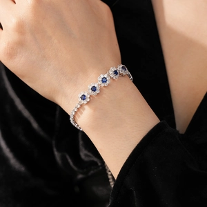 Détail macro d'un bracelet fleur en zircon avec pierre bleue sur monture argentée