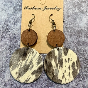 Detailed view of western retro earrings with wood and cowhide faux fur texture