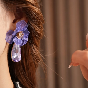 Detail of purple flower petal earrings with a large faceted water drop crystal drop