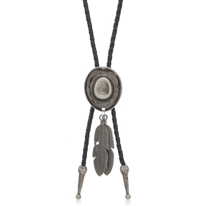 Detail of vintage silver cowboy hat and feather pendants on black braided leather bolo tie