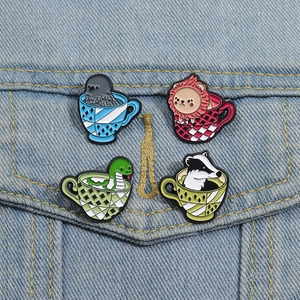 Detailed view of four animal themed enamel pins on a denim jacket pocket fabric