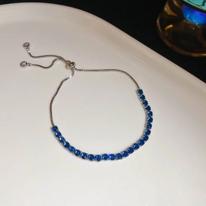 Detail of blue cubic zirconia bracelet with adjustable sliding clasp on white plate