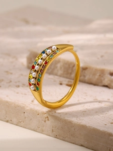 Detailed close-up of vintage gold band ring with colorful zircons and white pearls
